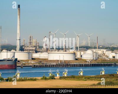 Il passato e il futuro dell'approvvigionamento energetico: Turbine eoliche e enormi serbatoi di stoccaggio del petrolio fuori da Rotterdam, nei Paesi Bassi. Il porto di Rotterdam è la Foto Stock