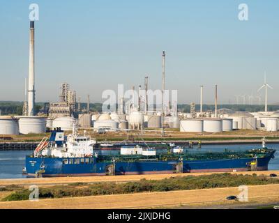 Il passato e il futuro dell'approvvigionamento energetico: Turbine eoliche e enormi serbatoi di stoccaggio del petrolio fuori da Rotterdam, nei Paesi Bassi. Il porto di Rotterdam è la Foto Stock