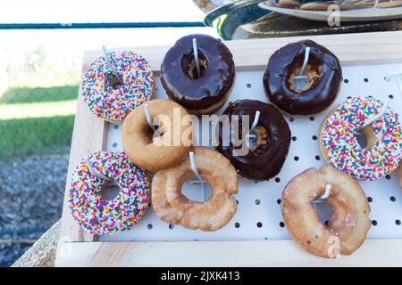 Ciambelle fresche assortite in mostra al picnic all'aperto Foto Stock