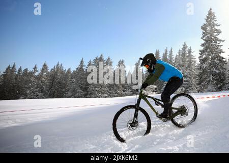 Sofia, Bulgaria - 22 gennaio 2022: Il ciclista percorre una discesa in bicicletta durante una gara estrema di mountain bike sulla neve sul monte Vitosha. Foto Stock