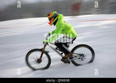 Sofia, Bulgaria - 22 gennaio 2022: Il ciclista percorre una discesa in bicicletta durante una gara estrema di mountain bike sulla neve sul monte Vitosha. Foto Stock