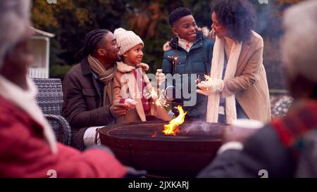 Famiglia Multi-Generation divertirsi insieme con i fuochi d'artificio nel Giardino d'autunno Foto Stock