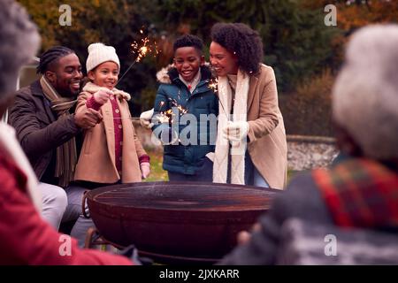 Famiglia Multi-Generation divertirsi insieme con i fuochi d'artificio nel Giardino d'autunno Foto Stock