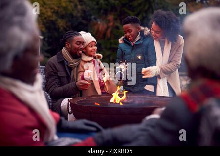 Famiglia Multi-Generation divertirsi insieme con i fuochi d'artificio nel Giardino d'autunno Foto Stock