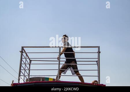 Goiânia, Goias, Brasile – 04 settembre 2022: Un giovane che balla in cima ad un trio elettrico. Foto scattata durante la sfilata LGBT a Goiânia. Foto Stock