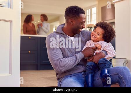 Padre e Figlio siediti su Step at Home mettere su Boots prima di andare sulla passeggiata della famiglia Foto Stock