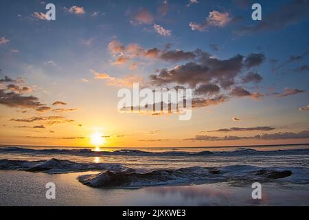 La vista mozzafiato dell'alba in inverno sul lago Huron al Tawas Point state Park Foto Stock