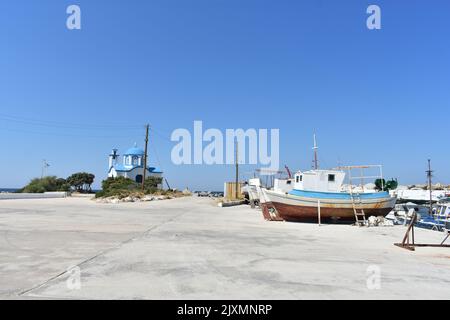 Mare Porto di Gialiskari nell'isola di Ikaria con la chiesa greca ortodossa di Analipsi di Gialiskari con le barche da pesca, isola di Ikaria, Grecia, Europa Foto Stock