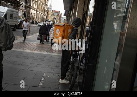 Fast food consegna ciclisti nelle strade della città, a Glasgow, Scozia, 7 settembre 2022. Foto Stock