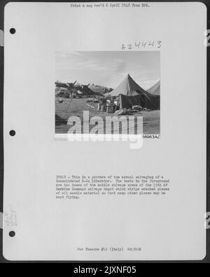 Italia - questa è una foto del recupero effettivo di Un Liberatore B-24 consolidato. Le tende nel primo piano sono le case degli equipaggi mobili di salvataggio del 15th AF Service Command Salvage Depot che stripe aerei relitti di tutto il materiale utilizzabile so T. Foto Stock