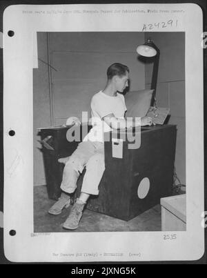 SGT. Ray Petit, 24, Cambridge Springs, Pa., Un meccanico radio, 15th AF con sede in Italia, è mostrato seduto in una sedia Ultra Easy che ha costruito da Belly Tank Crates. Dispone di vassoi di cenere integrati, radio, luce da lettura, scaffalatura per riviste, scomparti, Regolabile Foto Stock