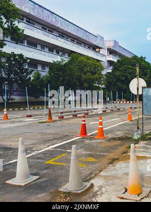 Test di guida e area di addestramento con test di simulazione per patente di guida. Scuola di guida pratica zona di traffico con pole segnaletica e coni arancioni e la strada Foto Stock