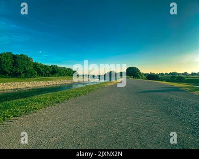 Una vista panoramica di una mattina limpida e soleggiata su un sentiero vicino ad un torrente Foto Stock