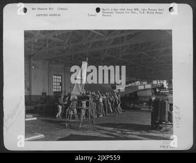 G.I. La meccanica di uno Squadrone di assemblaggio aeronautico in Italia e gli operai italiani preparano Un'ala dello Heinkel 111 per la spedizione negli Stati Uniti. Il bombardiere tedesco atterrò in Italia. Foto Stock