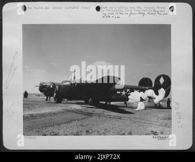 Il suo sistema idraulico sparato da Flak sul Ponte ferroviario di Ferrara nel Nord Italia, questo Bomber Liberatore consolidato B-24 del 15th AF atterrò con l'aiuto dei Paracuti impedendo alla lib di superare la striscia di atterraggio. Foto Stock