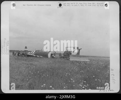 Crash atterrato aereo da combattimento vicino 834th Engineer Aviation Battalion bulldozer sulla costa di invasione St. Laurent sur Mer, Francia. Foto Stock