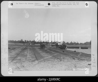 Gli uomini del 834Th ingegnere Aviazione Battaglione posa filo matting durante la costruzione di un campo d'aviazione a St. Pierre Du Mont, Normandia, Francia. Foto Stock