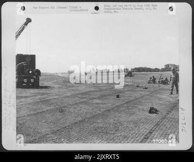 Gli uomini del 834Th ingegnere Aviazione Battaglione posa filo matting durante la costruzione di un campo d'aviazione a St. Pierre Du Mont, Normandia, Francia. Foto Stock