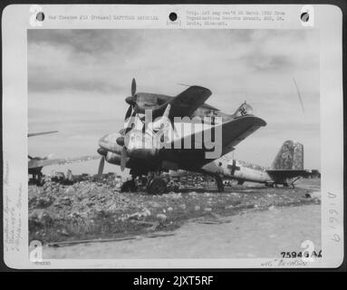 Un membro della truppa 439Th Carrier guarda su Un aereo catturato tedesco Junkers Piggy Back [Junkers Ju 88 e Focke Wulf FW 190] presso una base aerea da qualche parte in Francia. 4 maggio 1945. Foto Stock