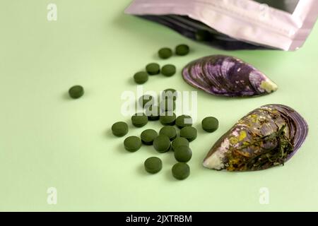 Primo piano del supplemento di iodio da kelp che fuoriesce dalla confezione, a sostegno della salute della ghiandola tiroidea. Un guscio con i resti di alghe Foto Stock