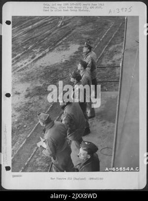 Ufficiali di Un gruppo di bomba 401St Peer in the Skies to Count aerei di ritorno da Un'operazione di bombardamento sul territorio Enemy-held. Gli ufficiali sono in piedi sulla passerella di Una torre di controllo dove sono in grado di mantenere un contatto radio costante con gli aerei. Foto Stock