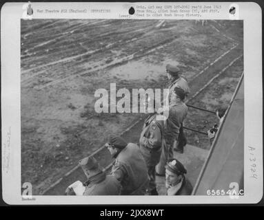 Ufficiali di Un gruppo di bomba 401St Peer in the Skies to Count aerei di ritorno da Un'operazione di bombardamento sul territorio Enemy-held. Gli ufficiali sono in piedi sulla passerella di Una torre di controllo dove sono in grado di mantenere un contatto radio costante con gli aerei. Foto Stock