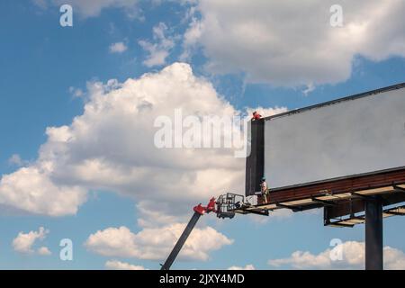 Lavoratori che installano un nuovo cartellone su cartellone vuoto, USA Foto Stock