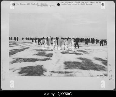La pulizia delle piste innevate è stata un lavoro notturno per centinaia di GI brividi di un gruppo nordamericano P-51 Mustang, che ha presidiato aratri e pale per rimuovere tre centimetri di neve in modo che i piloti potessero decolgere in una missione di combattimento precoce. Foto Stock