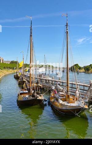 Veere, Paesi Bassi - 2022 agosto: Persone su tradizionali barche a vela in legno ormeggiate vicino alla città Foto Stock