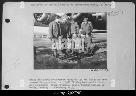 Gli uomini del gruppo di bombardamento del 457Th delle forze aeree del 8th hanno rimosso le armi dalla loro B-17 'Fortezza volante' Ath loro base in Inghilterra, dopo essere tornati da Una missione di bombardamento a Berlino, Germania. 3 febbraio 1945. Foto Stock