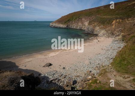 Una piccola insenatura di sabbia circondata da scogliere nel Galles occidentale, nel Regno Unito, appena a nord di Whitesands Bay, accessibile solo a piedi. Foto Stock