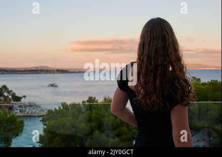 Non riconoscibile ragazza sta guardando al mare di fronte a Illetas, Maiorca Foto Stock