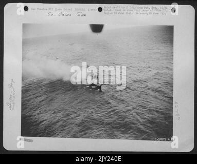 Indo-China - on Fire and Listing to Starboard dopo l'attacco da parte del Nord America B-25 del gruppo Air Apaches il 29 marzo 1945, la Destroyer Escort 'Frigate' spillerà il suo equipaggio sul lato come comincia a sink. Gli aerei attaccanti si allontanarono prima della G delle navi Foto Stock