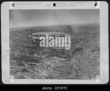 Sulle montagne della Cina occidentale, un Curtiss C-46 Commando si avvicina alla sua destinazione su un percorso volato dall'India China Div., ATC. Nel gennaio 1945, questa divisione ha messo più di 44.000 tonnellate di merci nella vecchia Cathay per via aerea. Foto Stock