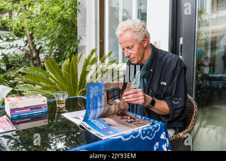 (220908) -- DALI, 8 settembre 2022 (Xinhua) -- Jos Van der Wiel legge una rivista a casa a Dali, provincia di Yunnan, nel sud-ovest della Cina, il 29 agosto 2022. Sono passati più di 40 anni da quando Jos Van der Wiel è venuto per la prima volta in Cina dai Paesi Bassi. Nel corso dei decenni, l'olandese si è appassionato di organizzare turisti in tutto il mondo per viaggiare in Cina in bicicletta. Durante i suoi tour in bicicletta, Jos ha conosciuto bene la Cina. Ha persino compilato una guida turistica per la Cina, che offre una guida completa ai lettori olandesi.nel 2000, mentre Jos esplorava nuovi percorsi per tour in bicicletta nella provincia dello Yunnan, nel sud-ovest della Cina, ha incontrato la sua curiosità Foto Stock