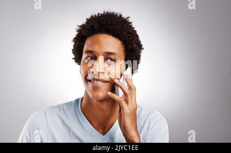 Rimani in contatto con la tua persona speciale... Studio scatto di un giovane uomo che parla sul suo cellulare. Foto Stock