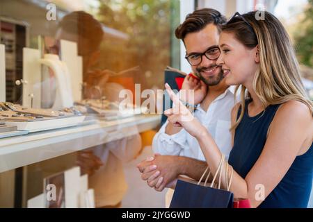 Ritratto di una coppia con borse shopping in città. La gente vende il concetto di amore e felicità. Foto Stock