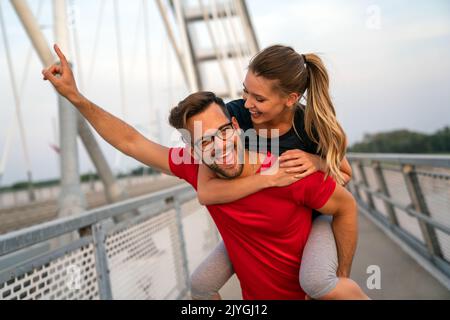 Allenamento di mattina presto. Coppia felice che corre attraverso il ponte. Vivere uno stile di vita sano. Foto Stock