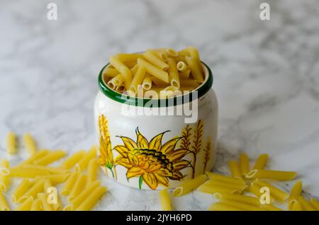 Penne la pasta nella ciotola, isolati su sfondo bianco, vista dall'alto Foto Stock