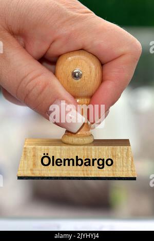 La mano della donna con la scritta del bollo Oelembargo, embargo del gas, Germania Foto Stock