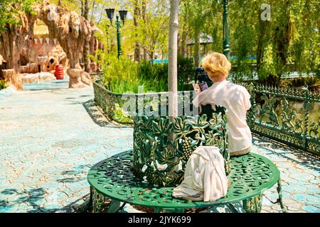 Matura bella donna viaggiatore, si siede sulla panchina del parco Foto Stock