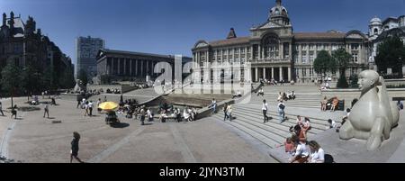 Una vista panoramica delle lenti di Victoria Square Birmingham. Fino all'edificio del comune (centro) ci sono dei gradini delimitati da due sculture di tipo Sphynx in pietra di dove Dale con la statua DEL FIUME Dhruva Mistry, chiamata localmente The Flozie nella Jacuzzi in cima. A destra si trova il Municipio a colonne con lo skyline della Alpha Tower. Foto Stock