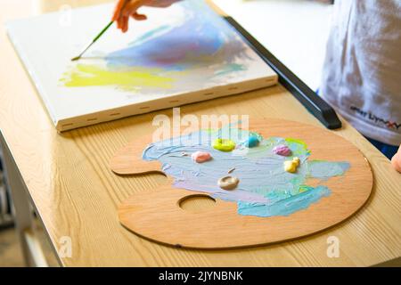 Pittura bambino su tela con pittura acrilica. Foto Stock