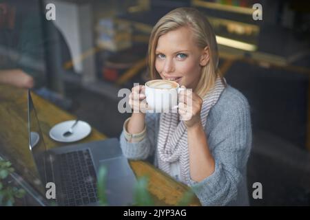 Abbiamo tutti bisogno di un posto per essere soli. Una giovane donna seduta in una caffetteria. Foto Stock