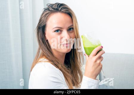 donna con un bicchiere di frullato di spinaci, concetto di salute, vegetariano Foto Stock