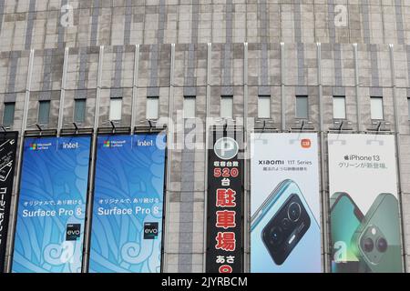 TOKYO, GIAPPONE - 14 agosto 2022: Cartelloni pubblicitari iphone, Microsoft Surface pro e Xiaomi smartphone su un negozio di fotocamere Yodobashi. Foto Stock