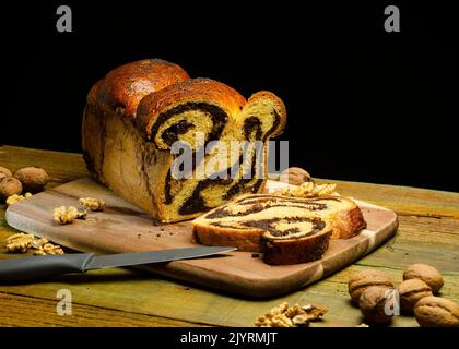 Fette di tradizionale pane dolce rumeno fatto in casa. Pagnotta di pane sul tavolo 'cozonaca' Foto Stock