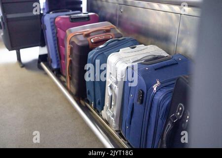 Bagagli su scaffale treno ferroviario. Vacanza, turismo, viaggi, interni moderni dei treni, concetto di trasporto ferroviario Foto Stock