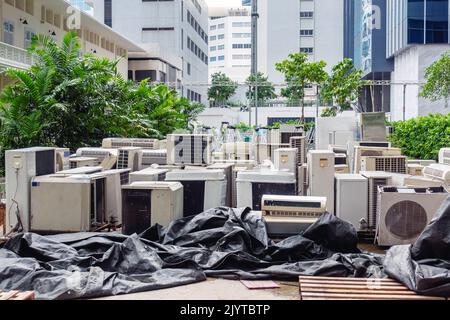 Un sacco di condizionatori d'aria impilati in un mucchio per lo smaltimento al riciclaggio rifiuti di scarico. Pila di condizionatori d'aria vecchi e sporchi difettosi e scartati Foto Stock