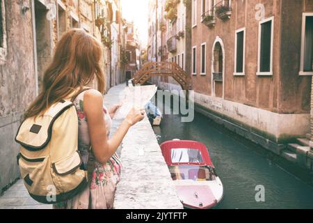 Traveler ragazza guarda la mappa di camminare a Venezia, Italia Foto Stock